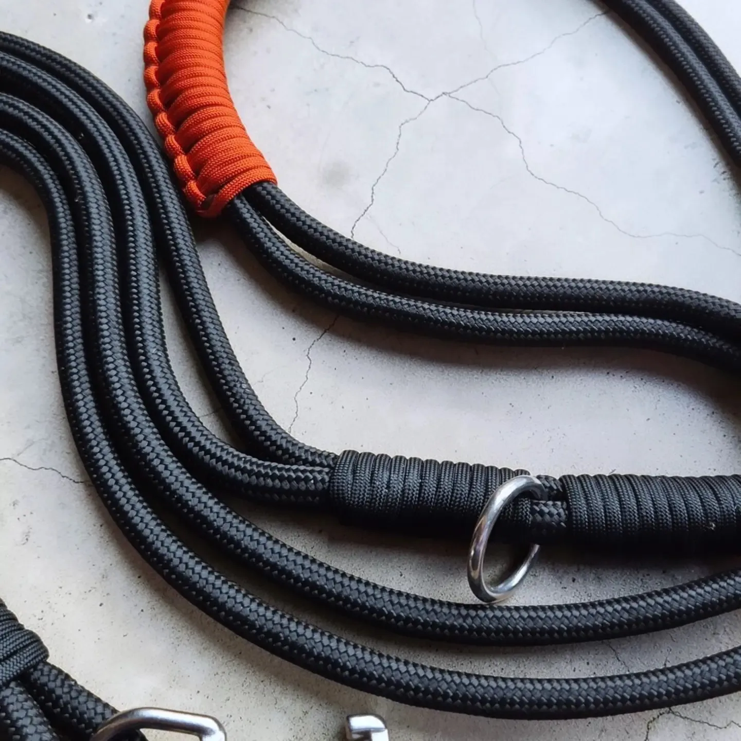 Close-up of a black rope lead with orange handle whipping